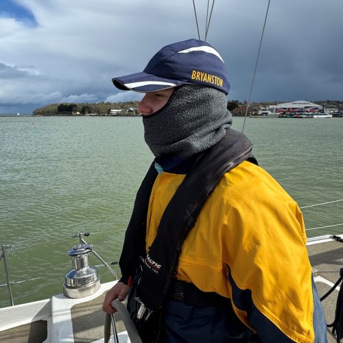 Boy wearing navy blue Bryanston hat is at the Helm