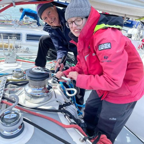 Skipper and young person with wet weather clothing on