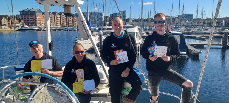 Crew holding thank you cards from young crew