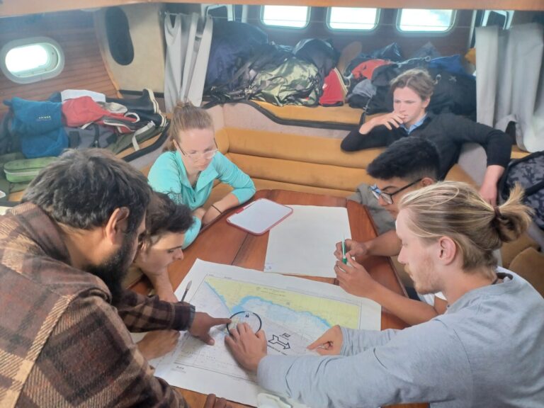 Alex and crew on the ketch practicing passage planning on a Leadership voyage on the Ketch