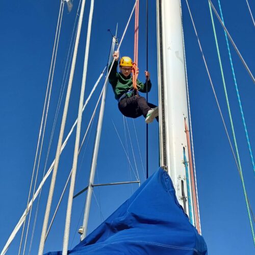 young person half way up the mast