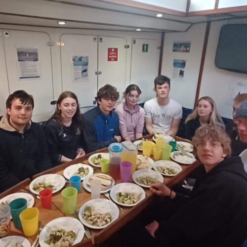young people on a sail eating in the snake pit