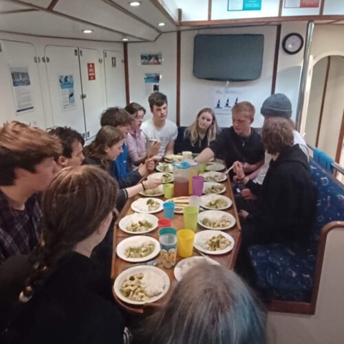 young people on a sail eating in the snake pit